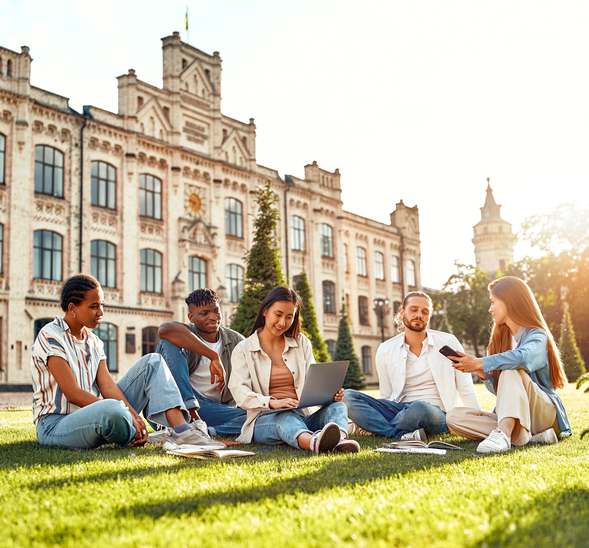 Diverse group of students on campus with laptop and smartphone